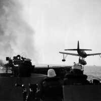 A Kingfisher float plane is airborne after being launched off one of IOWA