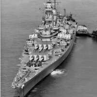 Bow view of USS Iowa anchored off New York with a trash barge placed at her port. April 7, 1943 - US Navy photo.