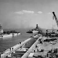 Tug boats guide IOWA towards the entrance of the dry dock still under construction. October 20, 1942 - 80-G-13565