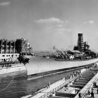 Tug boats push IOWA further into her dry dock as lines are sent out to workers on shore. October 10, 1942 - 80-G-13556