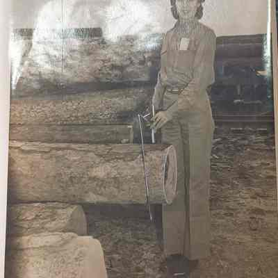 Photo of woman sawing a log