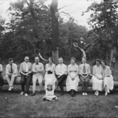 Group of Men and Women Sitting On Log