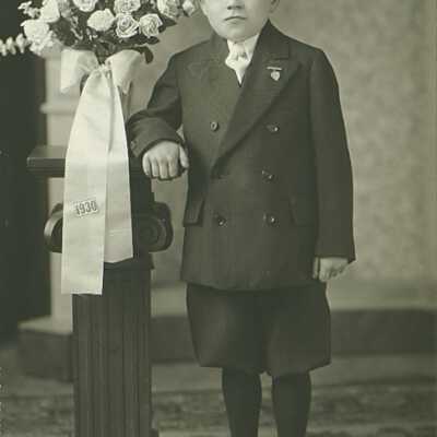 Boy Standing Next to Vase of Flowers "1930" Stitched on Ribbon