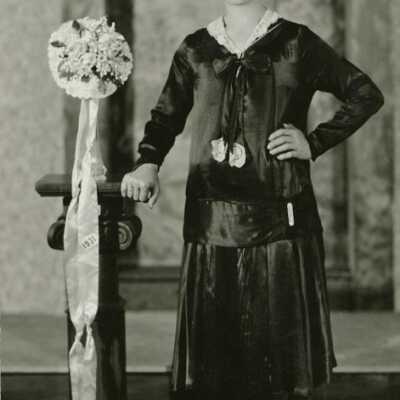 Woman Wearing Socks Next to a Bridal-type Bouquet with "1931" Stitched