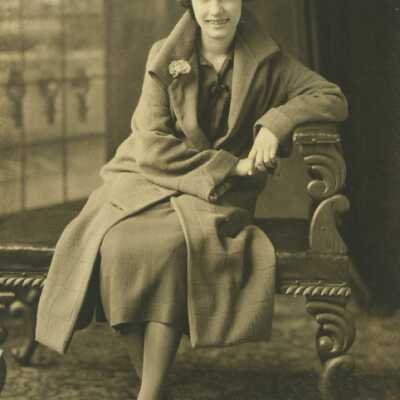 Young Woman Wearing Coat Sitting on Bench
