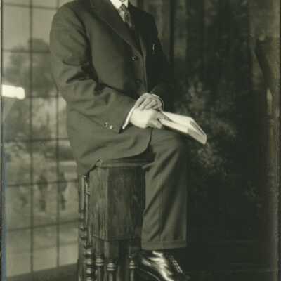 Man Wearing Spectacles Holding a Book