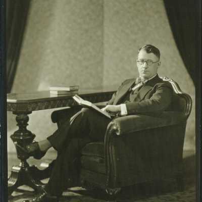 Man Wearing Spectacles Holding a Book