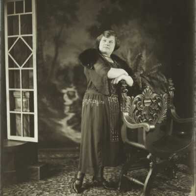 Woman Standing Behind Chair