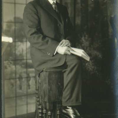 Man Wearing Spectacles Holding a Book