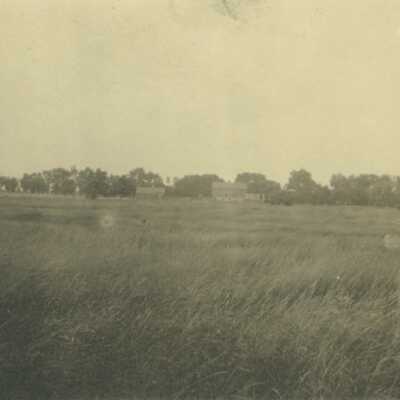 Farm Field with Barns in Background
