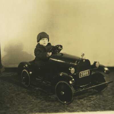 Boy Sitting in Toy Car