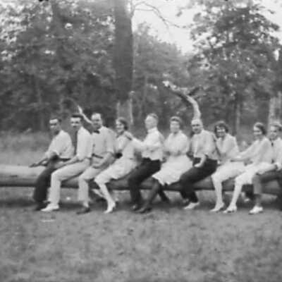 Group of Men and Women Straddling Log