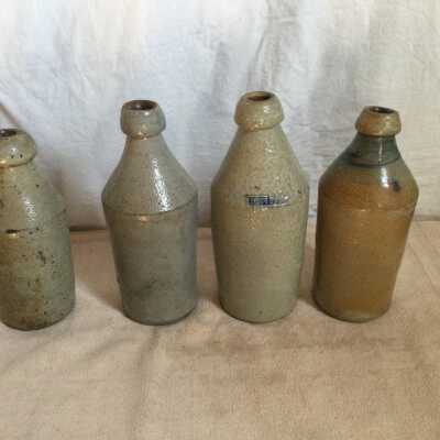 Group of Four Ceramic Beer Bottles