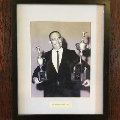 Framed photo of Stu Evans holding swimming trophies