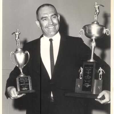 Photo of Evans holding this trophy (left). Framed copy on west wall main boathouse.