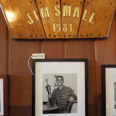 Board and Photo - Jim Small: Framed photo of Jim Small holding trophy
