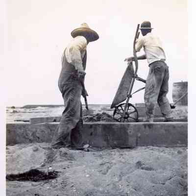 Two Men Constructing a Boardwalk or Seawall, July 1911