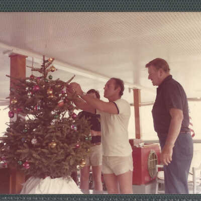 John Wayne, Bert Minshall, and Another Man Decorate a Christmas tree on The Wild Goose
