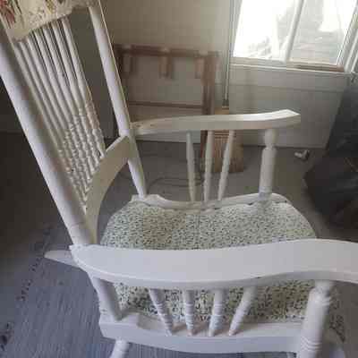 side view: Side view of chair, has the floral pattern cushion exposed