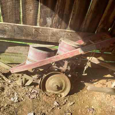 left view: Leftward view of the manual push fertilizer where only the bottom most can's damage is visible
