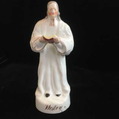 Sculpture of John Wesley in All White Holding a Book