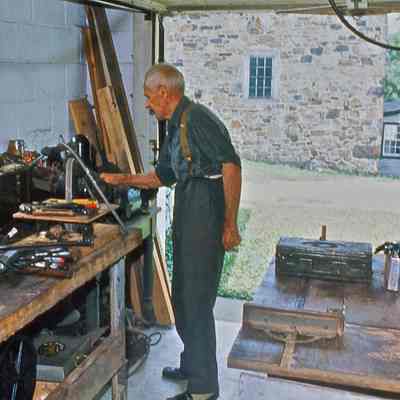 Oliver Collins in his garage workshop, post office next to mill