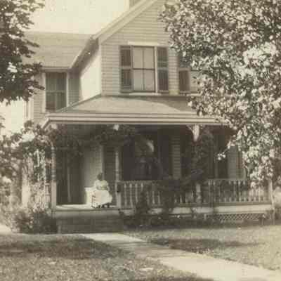 John Litzel House with a woman (Louisa Litzel?) sitting on the porch