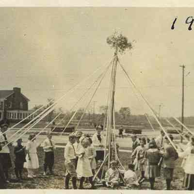 420.19 - Students with a maypole in the lawn of Shaker Heights Village School, located in the Van Sweringen sales office at Lee Road and Shaker Boulevard. 16350 Shaker Boulevard/2812 Lee Road, built in 1911, is visible in the background.