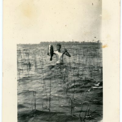 Man in Water Holding a Fish