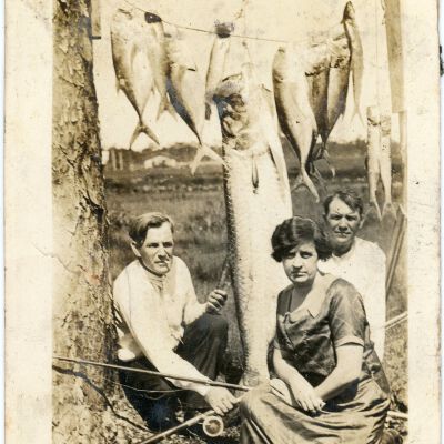 Two Men and a Woman with Hanging Fish