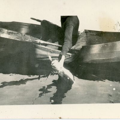 Person in a Canoe Holding a Fish