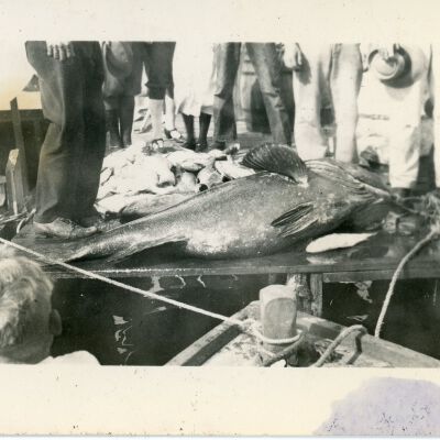 Figures Standing By a Fish