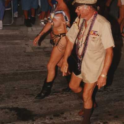 Two unknown people dressed up walking in the parade.