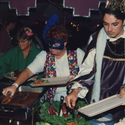 Unknown people serving themselves food from a buffet table.