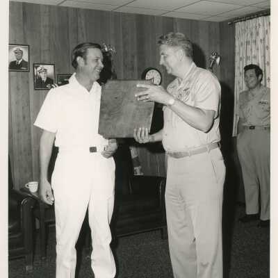 A man in uniform receiving a plaque at a ceremony