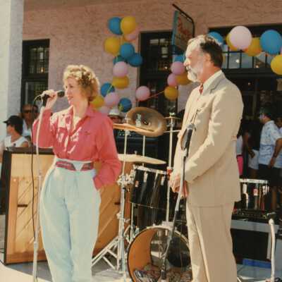 Two unknown people talking on a stage.