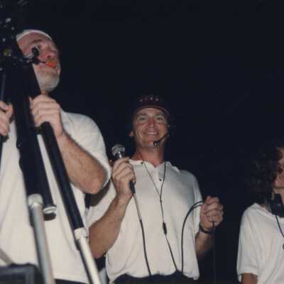 Three unknown people with microphones and video cameras.