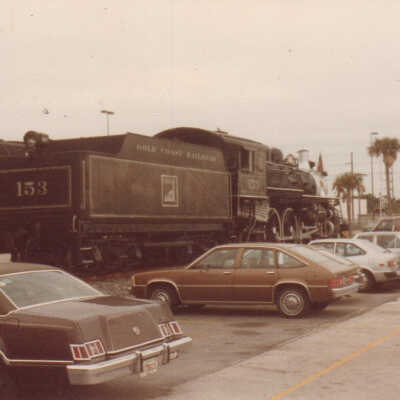 Cars parked near Gold Coast Railroad Locomotive #153