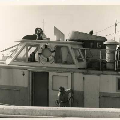 An unknown man in uniform cleaning a boat
