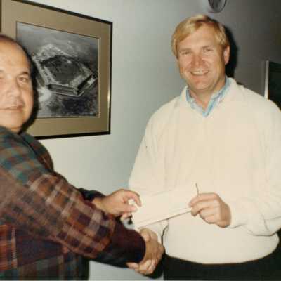 Two unknown men holding a check.
