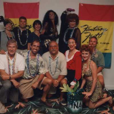 Unknown group of people standing in front of fantasy Fest flags.