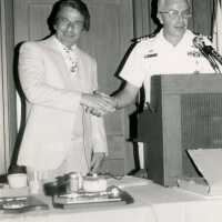 2 Unknown men shaking hands standing behind a podium