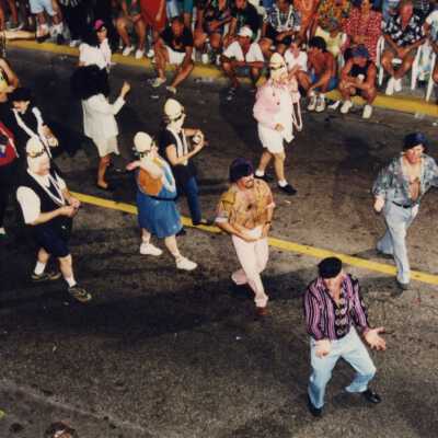 Unknown people dancing in the street in the parade.