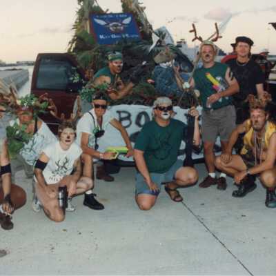 Unknown group of people dressed up with a few floats near by.