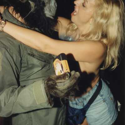 Unknown woman hugging an unknown man dressed as a gorilla.