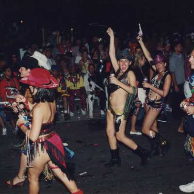 Unknown people dressed up dancing on the street for the parade.