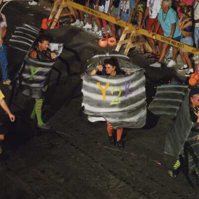 Unknown people dressed up walking in the street for the parade.