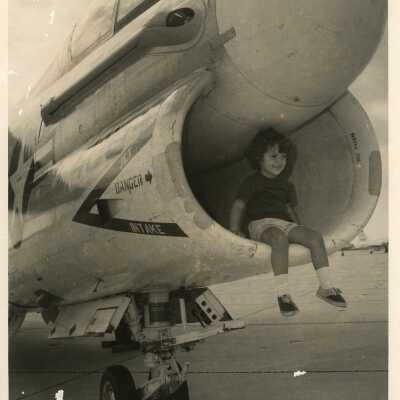Unknown child sitting on a military plane