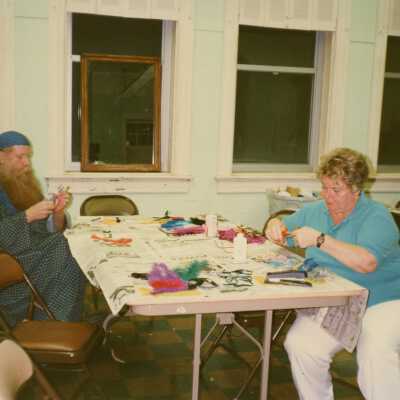 Two unknown people working on face mask.