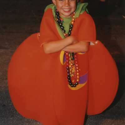 An unknown child dressed up as a pumpkin.